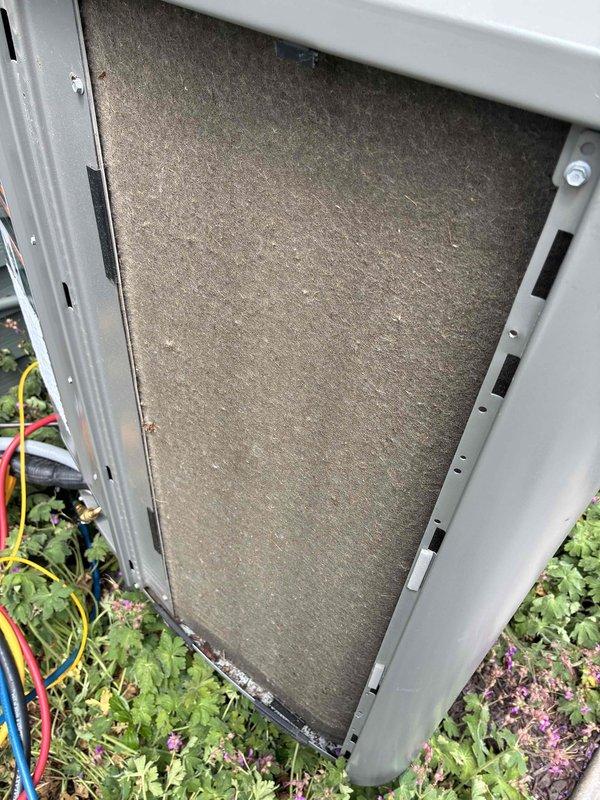Completed air conditioning tune-up service at residential property. Inspected outdoor condensing unit and found heavily soiled air filter with significant dust and debris accumulation restricting airflow. Removed and replaced dirty filter with new pleated HVAC filter to restore proper system ventilation and efficiency.