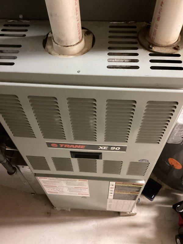 Responded to no cooling call on Trane XE 90 system. Upon arrival, found ice buildup on evaporator coil and outdoor fan motor not operating. Diagnosed failed condenser fan motor preventing proper heat rejection, causing system to ice up and shut down on safety. Replaced defective fan motor, verified proper rotation and amperage draw, allowed coil to thaw completely, and restored system to normal cooling operation with all safeties functioning correctly.