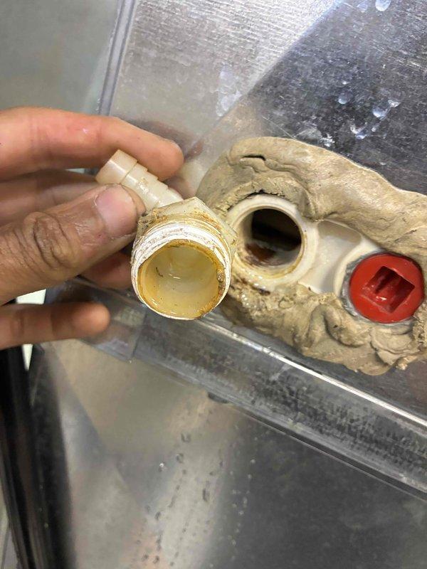 Responded to no cooling call on 10-year-old Carrier HVAC system for new homeowners requesting warranty coverage verification. Upon arrival, performed system inspection and diagnostics on furnace/air handler unit installed in mechanical room. During examination, discovered compromised condensate drain system with corroded brass manifold assembly showing significant age-related deterioration, discoloration, and moisture accumulation on surrounding components. The drainage hardware exhibited brown staining and corrosion at connection points, indicating potential blockage or drainage failure contributing to system malfunction. Inspected PEX tubing connections and drain line routing from unit. Documented equipment condition and warranty-eligible components with photographic evidence for manufacturer claim submission. System requires condensate drain assembly replacement to restore proper operation and prevent future cooling interruptions.