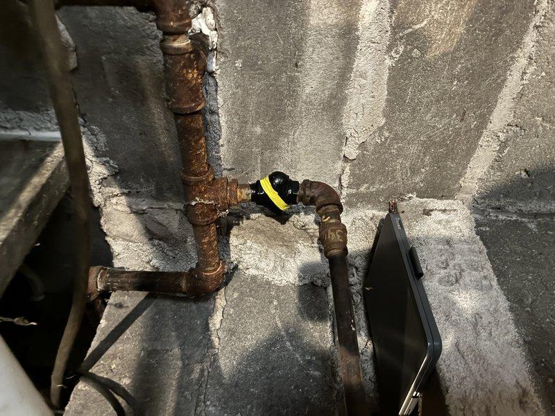 Responded to gas company-marked leak on valve in basement plumbing system. Upon inspection, identified small gas leak at valve connection point on aging copper gas line with visible corrosion. Repaired leak at valve assembly, performed pressure test to verify system integrity, and confirmed no additional leaks present in accessible piping.