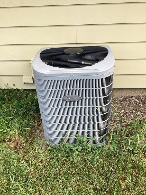 Responded to service call for intermittent cooling issue on Carrier outdoor condensing unit. Upon arrival, performed visual inspection of equipment and noted vegetation growth around base of unit and debris accumulation near condenser coils. Unit appeared to be operational but likely experiencing reduced airflow efficiency due to restricted airflow around heat exchanger fins, which could cause intermittent cooling performance and reduced system capacity during peak demand periods.