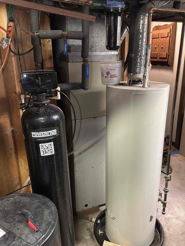 Completed on-site evaluation of existing HVAC system for replacement estimate. Assessed aging natural gas furnace located in basement mechanical room and exterior air conditioning condenser unit. Furnace had experienced operational issues during previous winter season. Documented current equipment conditions through photographic inspection, noting weathered outdoor condenser unit with visible aging and indoor furnace installation alongside water treatment equipment. Provided comprehensive replacement options including furnace-only replacement and combined furnace and AC system replacement to address customer's heating and cooling needs.