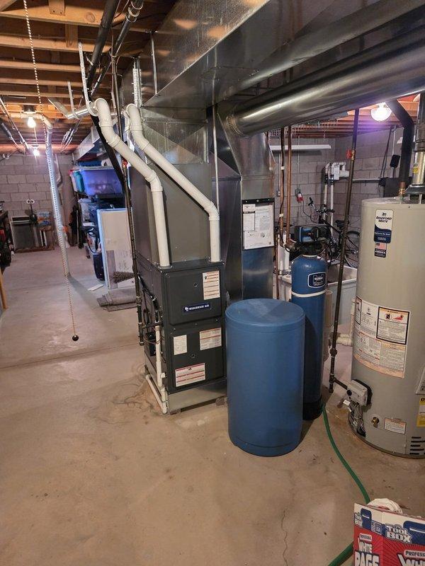 Completed full air conditioning and evaporator coil installation in basement mechanical room. Installation was permitted and included coordination with licensed electrician for proper electrical connections. New A/C condenser unit was installed exterior to the home with corresponding indoor evaporator coil mounted to existing furnace system. All refrigerant lines were properly sized, insulated, and connected between outdoor and indoor components. System was evacuated, pressure tested, and charged to manufacturer specifications. Verified proper airflow, drainage through condensate lines, and electrical connections at both indoor and outdoor units. Tested system operation through complete cooling cycle to ensure proper function of compressor, fan motors, and thermostat communication. All work completed to code requirements with permit approval.