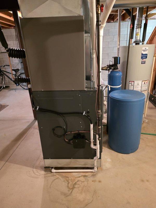 Completed full air conditioning and evaporator coil installation in basement mechanical room. Installation was permitted and included coordination with licensed electrician for proper electrical connections. New A/C condenser unit was installed exterior to the home with corresponding indoor evaporator coil mounted to existing furnace system. All refrigerant lines were properly sized, insulated, and connected between outdoor and indoor components. System was evacuated, pressure tested, and charged to manufacturer specifications. Verified proper airflow, drainage through condensate lines, and electrical connections at both indoor and outdoor units. Tested system operation through complete cooling cycle to ensure proper function of compressor, fan motors, and thermostat communication. All work completed to code requirements with permit approval.