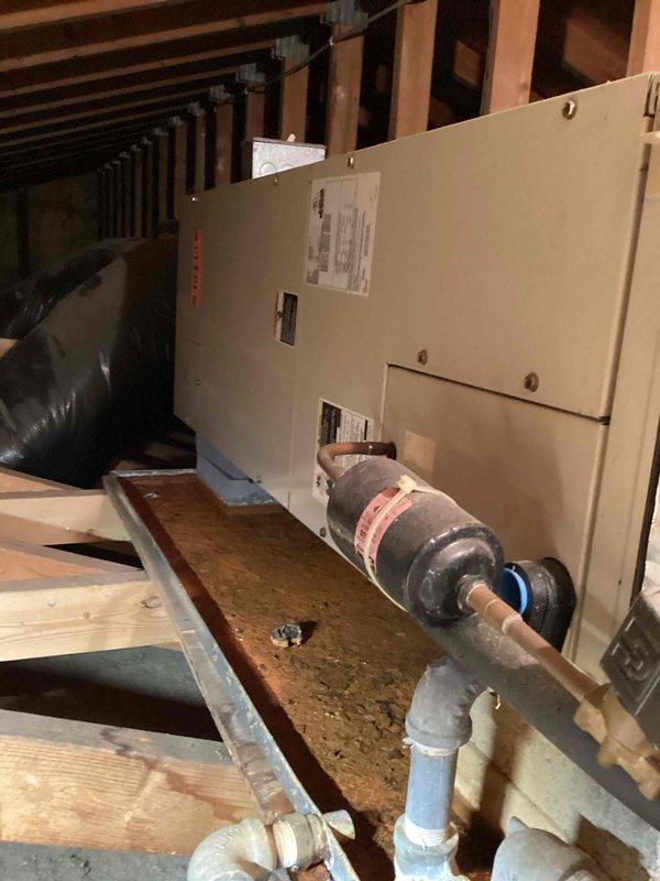 Responded to no cooling call on system over 10 years old. Upon arrival, inspected attic-mounted air handler unit and found motor component with visible wear and degraded condition. Evaluated outdoor condensing unit and drainage system, which showed significant debris accumulation, clogged drain lines, and restricted airflow around equipment. Cleared drain lines of organic matter and sediment buildup that was impeding proper condensate removal. System required comprehensive assessment of aging components to restore cooling functionality.