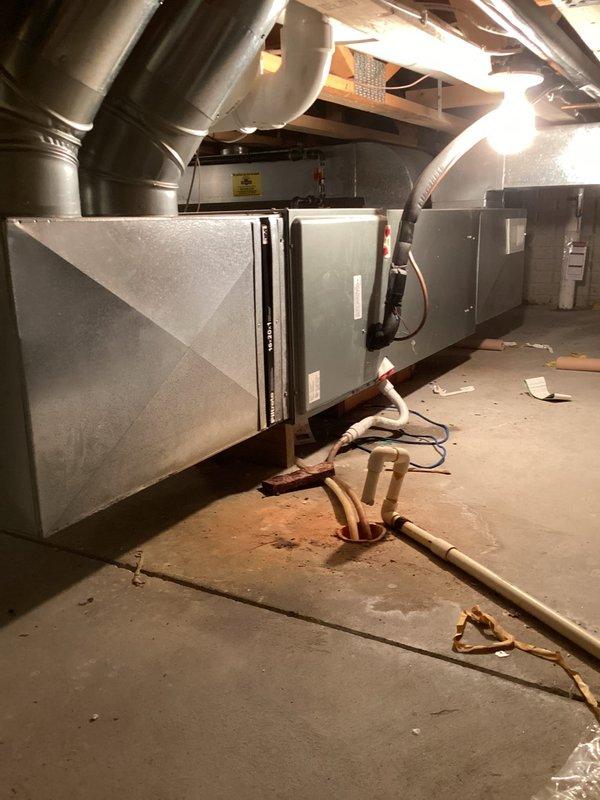 Responded to no cooling complaint on residential HVAC system. Upon arrival, located air handler unit in basement mechanical room and performed diagnostic evaluation of equipment over 10 years old. Documented existing system configuration including ductwork connections and refrigerant line routing. Captured photos of equipment location and surrounding mechanical area for service records.