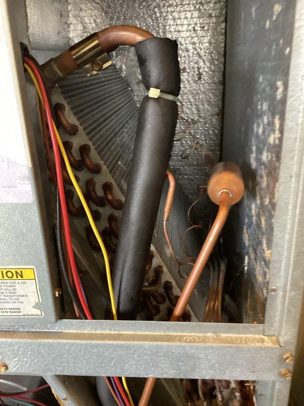 Responded to no cooling complaint on unit 5103. Upon arrival, accessed the indoor air handler and inspected the evaporator coil assembly and refrigerant line connections. Performed diagnostic evaluation of the system components, including examination of the refrigerant lines, electrical connections, and control mechanisms. Documented system conditions with photographs showing the insulated suction line, evaporator coil, copper refrigerant piping, and associated wiring. The evaporator coil exhibited dust accumulation on the fins, which can restrict airflow and reduce cooling efficiency. Inspected all visible electrical connections, control wiring, and brass valve components for proper operation.