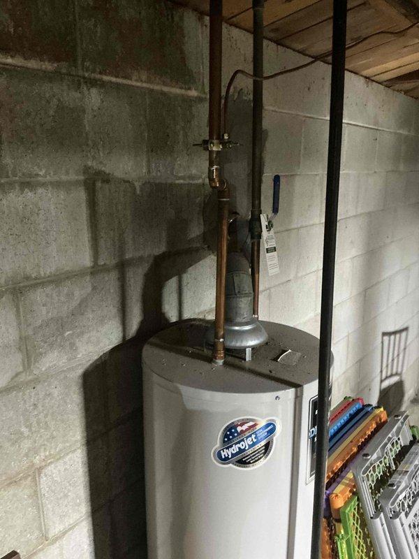 Responded to service call for non-functional water heater in residential basement. Upon arrival, assessed existing HydroPro brand water heater with connected copper supply lines, temperature and pressure relief valve, discharge piping, and mounted expansion tank. Provided comprehensive estimate for complete water heater replacement system to restore hot water service to occupied residence with children present.