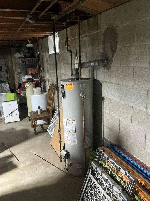 Responded to service call for non-functional water heater in residential basement. Upon arrival, assessed existing HydroPro brand water heater with connected copper supply lines, temperature and pressure relief valve, discharge piping, and mounted expansion tank. Provided comprehensive estimate for complete water heater replacement system to restore hot water service to occupied residence with children present.