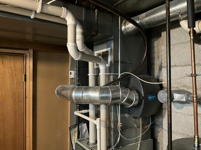 Conducted estimate for complete furnace and air conditioning system replacement in basement location. Evaluated existing natural gas furnace installation, assessed ductwork configuration including horizontal metal supply plenum, and documented current equipment specifications. Reviewed basement utility space layout with concrete block walls, exposed ceiling joists, existing PVC condensate drainage system, and copper refrigerant line routing for comprehensive replacement planning. Discussed available promotional options and provided equipment recommendations based on site conditions.