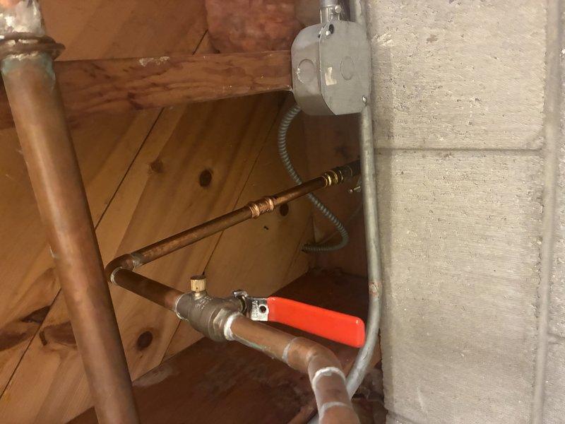 Responded to service call for leaking exterior hose faucet. Upon inspection, identified compromised ball valve with red handle connected to copper supply line in utility area. Valve exhibited signs of wear and active leak at connection point. Assessed existing copper piping configuration, including vertical runs and 90-degree elbow joints. Determined replacement of ball valve assembly was necessary due to extent of deterioration. Completed diagnostic evaluation of plumbing system to verify proper water flow and pressure post-repair recommendations.