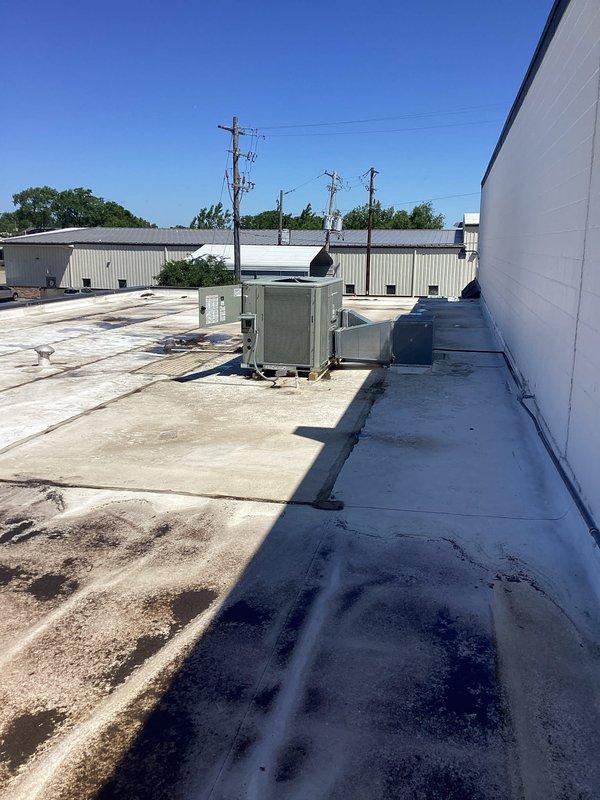 Completed commercial rooftop unit installation on flat membrane roof. Coordinated equipment delivery and crane service for proper placement of new RTU alongside existing rooftop HVAC equipment. Unit positioned on raised curb, with all rigging, electrical connections, and startup procedures executed per manufacturer specifications.