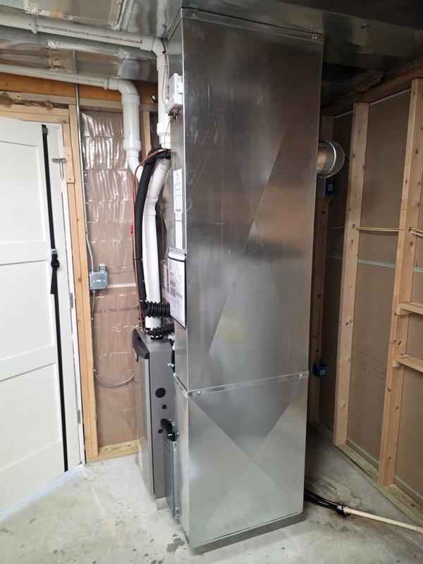 Completed full HVAC system installation in residential utility room, including new furnace and air conditioning unit with proper refrigerant line connections, electrical conduit, and PVC condensate drainage. All work performed with required permits and licensed electrician on-site, system tested and operational upon completion.