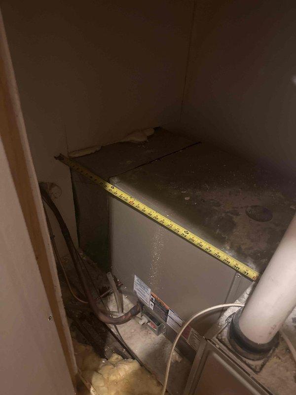 Completed comprehensive HVAC system replacement estimate for residential property, evaluating existing air handler unit located in basement utility closet and associated ductwork extending through attic space. Documented current equipment condition showing significant age-related wear, dust accumulation, and moisture concerns on concrete flooring, while assessing attic infrastructure including PVC condensate drainage lines, blown-in insulation coverage, and available access pathways for new equipment installation.