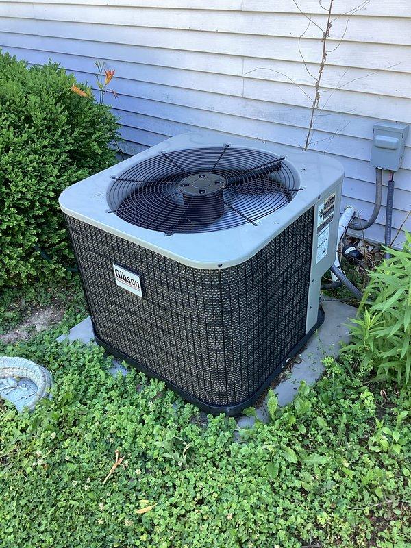 Responded to service call for continuous dripping from indoor evaporator coil on Gibson air handler unit located in attic space. Upon inspection, confirmed active condensate leak from 5-6 year old indoor coil assembly. Documented existing system conditions including air handler installation, condensate drain line configuration with PVC piping and securing straps, and outdoor condensing unit positioned on concrete pad with proper clearances. Photographed equipment and leak source for service records and provided recommendations for repair options to address the continuous drip issue affecting the HVAC system performance.