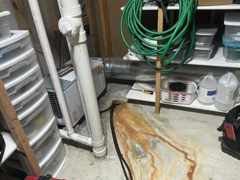 Responded to service call for non-operational dehumidifier system. Upon arrival, performed thorough assessment of existing Aprilaire whole-home dehumidifier unit located in basement utility area. Observed significant rust-colored water staining on concrete floor near equipment, indicating previous moisture issues or drainage problems. Inspected unit condition, drainage lines, and surrounding HVAC components. Documented equipment model information and current installation configuration. Photographed existing conditions including water damage evidence, unit placement, and associated plumbing connections. Provided comprehensive estimate for dehumidifier replacement to address non-functional unit and prevent further moisture-related issues in the space.