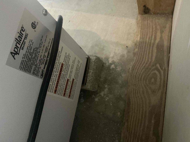 Responded to service call for non-operational dehumidifier system. Upon arrival, performed thorough assessment of existing Aprilaire whole-home dehumidifier unit located in basement utility area. Observed significant rust-colored water staining on concrete floor near equipment, indicating previous moisture issues or drainage problems. Inspected unit condition, drainage lines, and surrounding HVAC components. Documented equipment model information and current installation configuration. Photographed existing conditions including water damage evidence, unit placement, and associated plumbing connections. Provided comprehensive estimate for dehumidifier replacement to address non-functional unit and prevent further moisture-related issues in the space.
