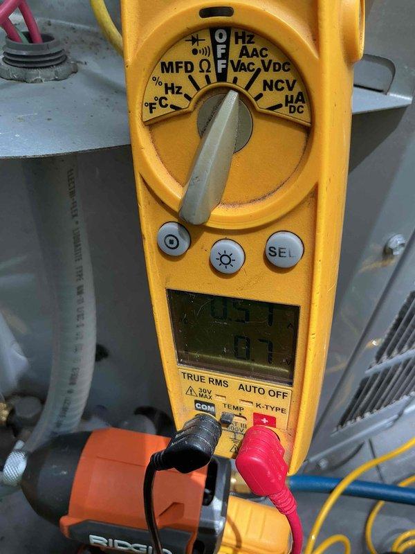 Completed two air conditioning tune-ups at the property, performing standard maintenance procedures including cleaning debris from the bottom of both units and documenting the work with before and after photographs. Verified system electrical readings using a digital multimeter, confirming proper voltage and capacitance levels on both HVAC units to ensure optimal performance for the cooling season.