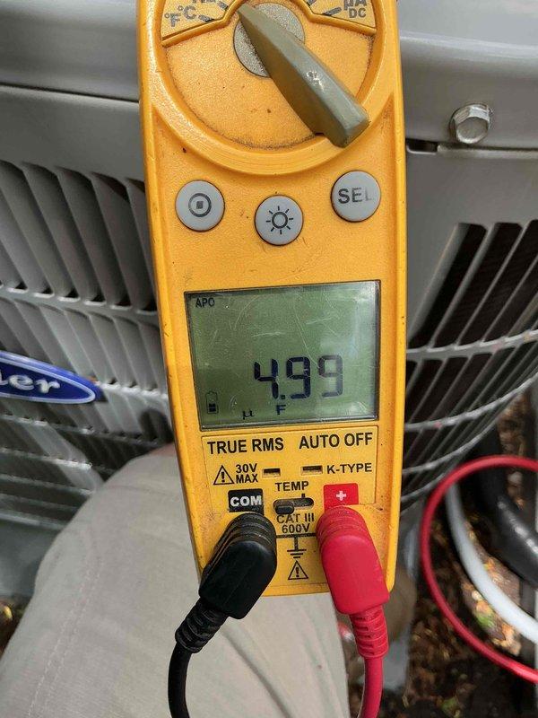 Completed two air conditioning tune-ups at the property, performing standard maintenance procedures including cleaning debris from the bottom of both units and documenting the work with before and after photographs. Verified system electrical readings using a digital multimeter, confirming proper voltage and capacitance levels on both HVAC units to ensure optimal performance for the cooling season.