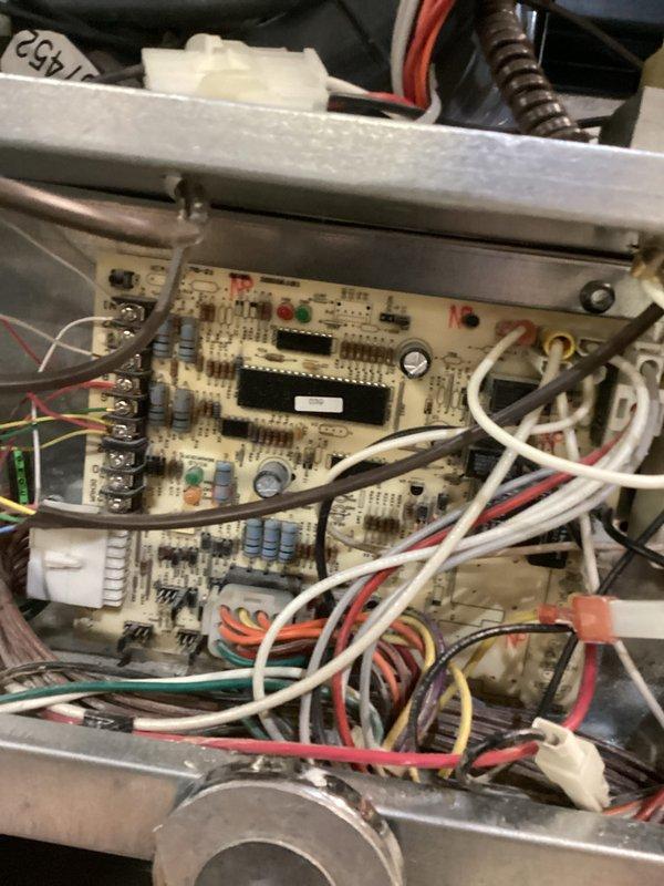 Responded to no heating and cooling call on aging HVAC system with reported previous power surge. Upon inspection, accessed furnace control board and found dual circuit boards with multiple electrical connections intact but verified system functionality after suspected electrical event. Documented equipment condition including condensate drainage system, gas connections, and control board components showing various indicator lights and terminal connections, confirming all wiring harnesses and safety controls were properly seated and operational.