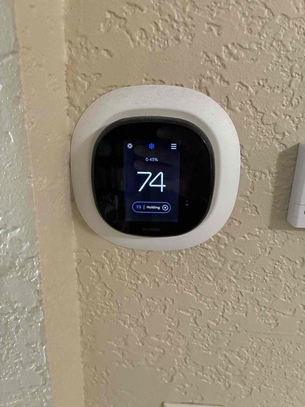 Conducted estimate for complete HVAC system replacement including natural gas furnace and air conditioning unit. Existing furnace located in basement is operational but experiencing extended run times to reach desired temperature settings due to age and decreased efficiency. Evaluated electrical panel showing 30-amp Square D circuit breaker and existing ecobee digital thermostat currently set to 74 degrees in heating mode. Recommended full system replacement to restore proper heating and cooling performance.