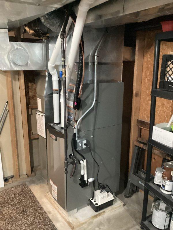 Completed full HVAC system installation including new furnace and air conditioning unit in basement utility area. System installed on concrete pad with proper venting through PVC exhaust piping, condensate pump placement, and electrical connections coordinated with licensed electrician. All work performed under permit with professional ductwork connections and organized routing of refrigerant lines and drainage components.