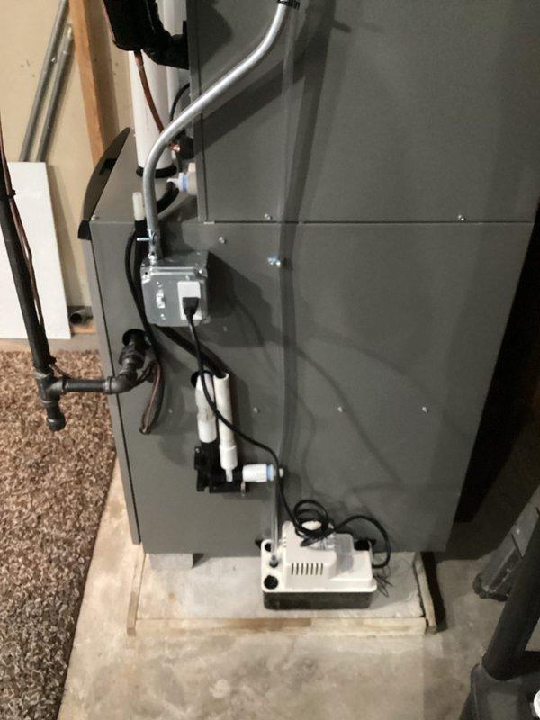 Completed full HVAC system installation including new furnace and air conditioning unit in basement utility area. System installed on concrete pad with proper venting through PVC exhaust piping, condensate pump placement, and electrical connections coordinated with licensed electrician. All work performed under permit with professional ductwork connections and organized routing of refrigerant lines and drainage components.