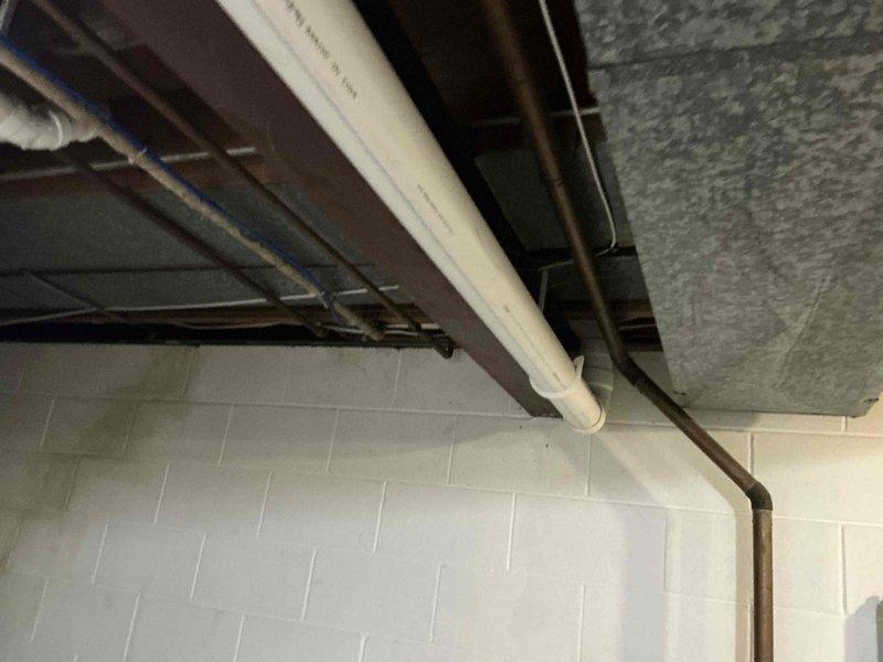 Conducted comprehensive assessment of existing natural gas furnace system located in basement mechanical room for replacement estimate. Evaluated current HVAC unit configuration, existing ductwork connections, PVC venting system, and electrical supply routing. Documented equipment specifications, installation clearances, and mechanical infrastructure including gas line accessibility and condensate drainage setup. Reviewed basement utility space layout with exposed ceiling joists, support structures, and existing ventilation components to determine optimal replacement equipment specifications and installation requirements.