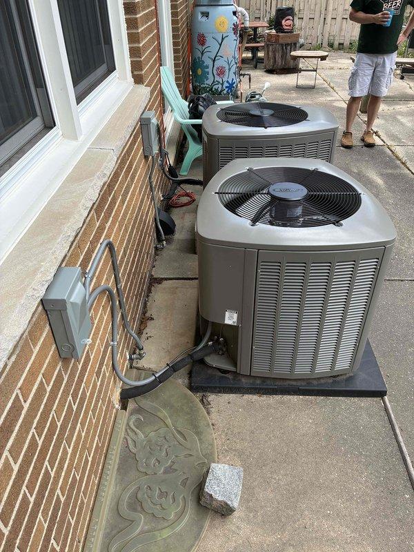 Provided estimate for disconnecting and reconnecting two outdoor condenser units to accommodate new patio installation. The dual-unit system, currently installed on a concrete pad along the brick exterior, will require temporary disconnection of refrigerant lines, electrical connections, and condensate drainage during the patio construction process, with full reconnection and system testing upon completion of the concrete work expected to take approximately five days.