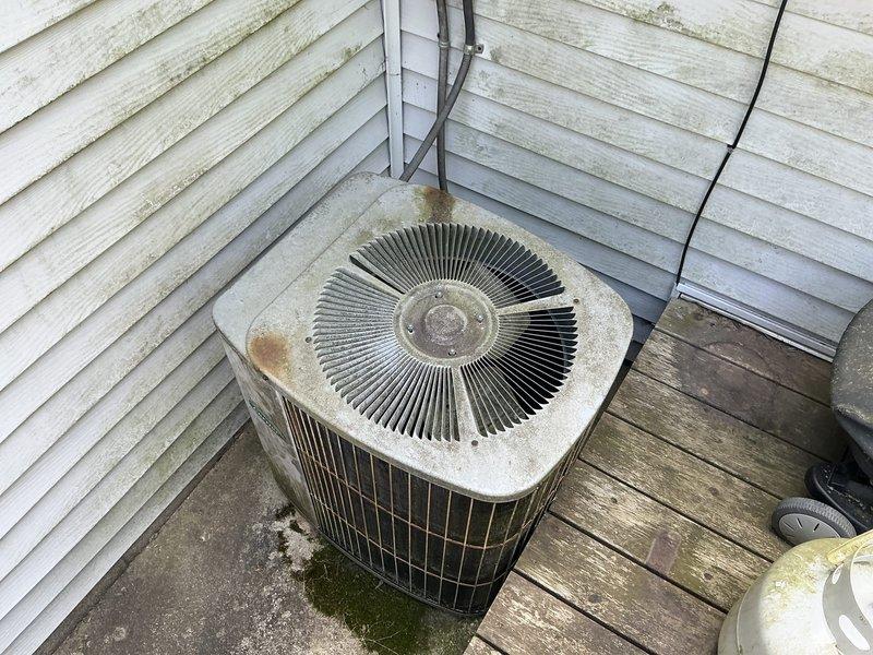 Responded to emergency service call for non-operational air conditioning system. Successfully restored system to working condition during initial visit. Conducted comprehensive site assessment for replacement estimate during follow-up appointment. Evaluated existing outdoor condenser unit showing significant age-related deterioration, including weathering, discoloration, and rust staining on cabinet surfaces. Inspected basement mechanical area, documenting existing infrastructure including copper refrigerant lines, gas piping, and PVC drainage system. Assessed installation location on exterior wooden deck and reviewed accessibility for equipment replacement. Photographed current system configuration and surrounding conditions to support replacement recommendations.