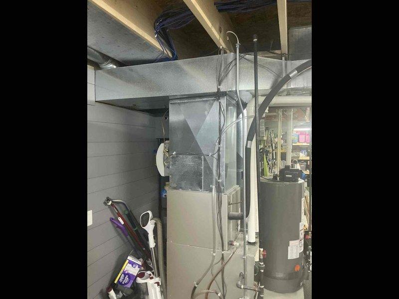 Responded to service call for noisy blower on operational furnace system. Upon inspection, evaluated existing HVAC equipment including furnace/air handler unit and associated ductwork in basement utility area. Documented current system configuration with water heater proximity and existing mechanical layout. Provided estimate for complete HVAC system replacement to address blower noise issue and aging equipment concerns.