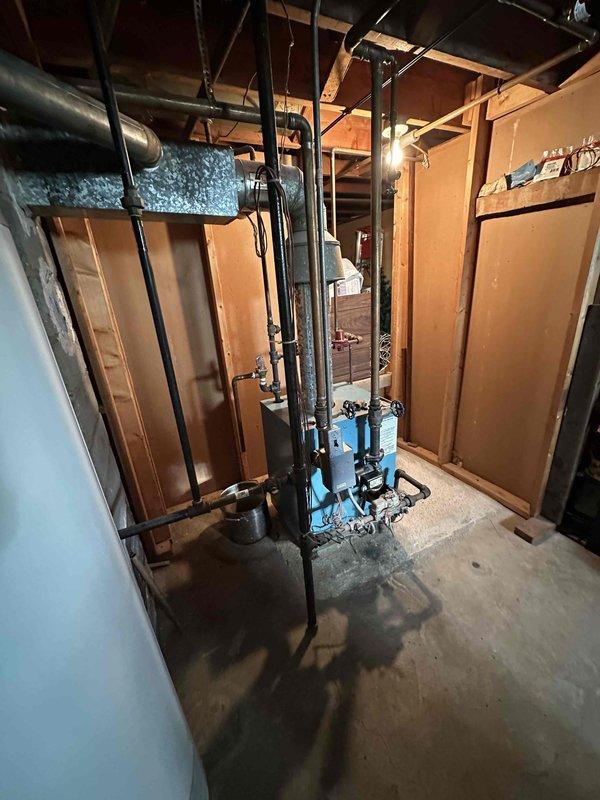 Conducted on-site evaluation for boiler replacement in residential basement mechanical room. System found to be non-operational and requiring full replacement. Documented existing electrical panel configuration, current HVAC equipment layout including furnace unit, plumbing infrastructure with water treatment components, and available workspace for new boiler installation. Assessed electrical service capacity and existing piping connections to determine scope of replacement work and equipment specifications needed for proper system sizing and installation planning.