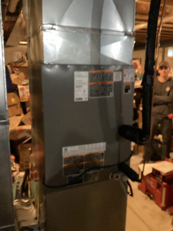 Completed installation of two complete air conditioning systems including indoor evaporator coils and outdoor condensing units. First system installed in basement mechanical room with new air handler unit properly positioned and connected to existing ductwork via metal supply plenum. Second outdoor condensing unit installed on ground-level pad against building exterior with electrical disconnect, refrigerant line set, and condensate drain piping routed through exterior wall. All electrical connections terminated per manufacturer specifications, refrigerant lines properly insulated, and systems tested for proper operation.