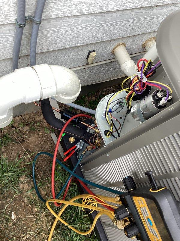 Completed installation of two complete air conditioning systems including indoor evaporator coils and outdoor condensing units. First system installed in basement mechanical room with new air handler unit properly positioned and connected to existing ductwork via metal supply plenum. Second outdoor condensing unit installed on ground-level pad against building exterior with electrical disconnect, refrigerant line set, and condensate drain piping routed through exterior wall. All electrical connections terminated per manufacturer specifications, refrigerant lines properly insulated, and systems tested for proper operation.