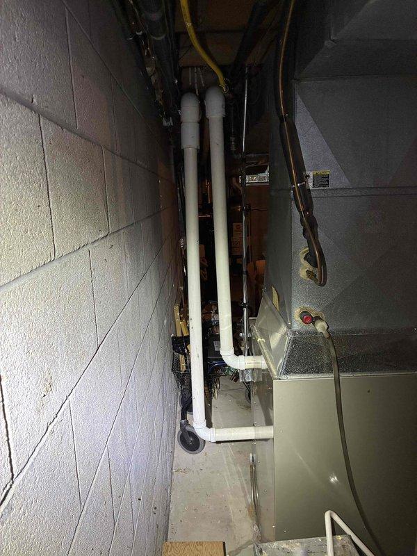 Conducted on-site assessment for complete HVAC system replacement in basement mechanical room. Evaluated existing aging furnace and air conditioning system, documenting current equipment configuration including gas line routing, venting arrangement, and drainage conditions. Photographed mechanical space layout, existing ductwork connections, PVC vent piping, copper refrigerant lines, and floor drain with visible water staining indicating potential condensate management concerns. Provided comprehensive replacement estimate for new high-efficiency heating and cooling equipment suitable for basement installation.