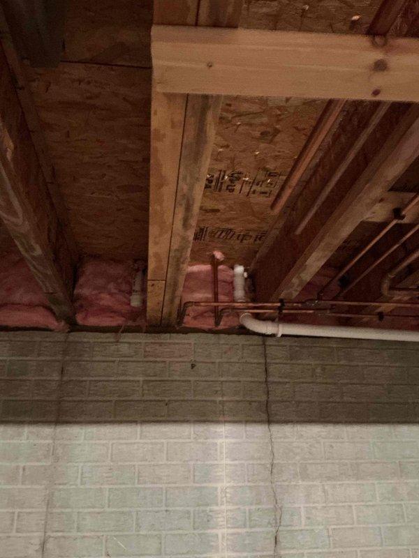 Completed pre-remodeling plumbing inspection of residential property. Examined existing plumbing infrastructure in basement/crawl space area, including copper supply lines and associated fittings mounted to floor joists. Assessed kitchen plumbing serving double-basin sink installation with existing drain and supply connections beneath granite countertop. Documented current plumbing conditions and configurations through photographic evidence to establish baseline for upcoming remodeling work. All existing plumbing systems evaluated for compatibility with planned renovation scope.