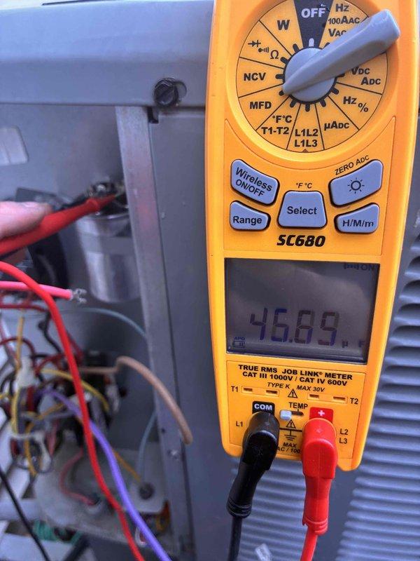 Completed comprehensive air conditioning tune-up and system diagnostics. Performed electrical testing using digital multimeter, recording capacitor readings of -46.89 MFD on system components, and measured operating temperature of 537°F at heat exchanger assembly. Inspected all electrical connections, control panel wiring, and HVAC equipment components to ensure proper system operation and performance.