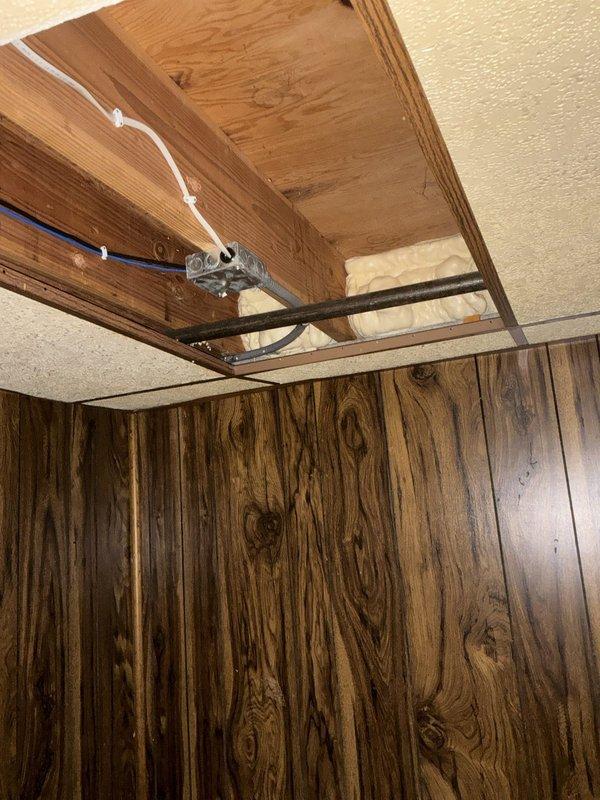 Conducted on-site assessment for new gas line installation to supply fireplace. Evaluated attic space routing options, existing utility pathways, and structural considerations for proper gas piping placement. Documented attic access area showing exposed wooden framing, existing electrical conduits, and available routing corridors for safe gas line installation per code requirements.