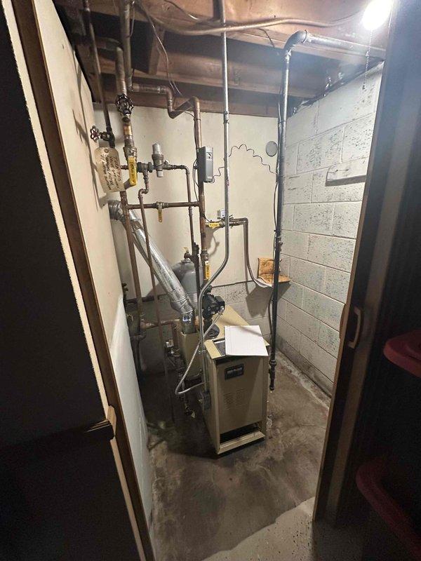 Conducted on-site evaluation of existing residential boiler system in basement mechanical room for replacement estimate. Assessed current heating unit configuration, associated piping infrastructure including copper and PEX supply lines, multiple shut-off valves, and distribution system connections. Documented electrical service panel with main breaker and circuit configuration to determine compatibility requirements for new boiler installation.