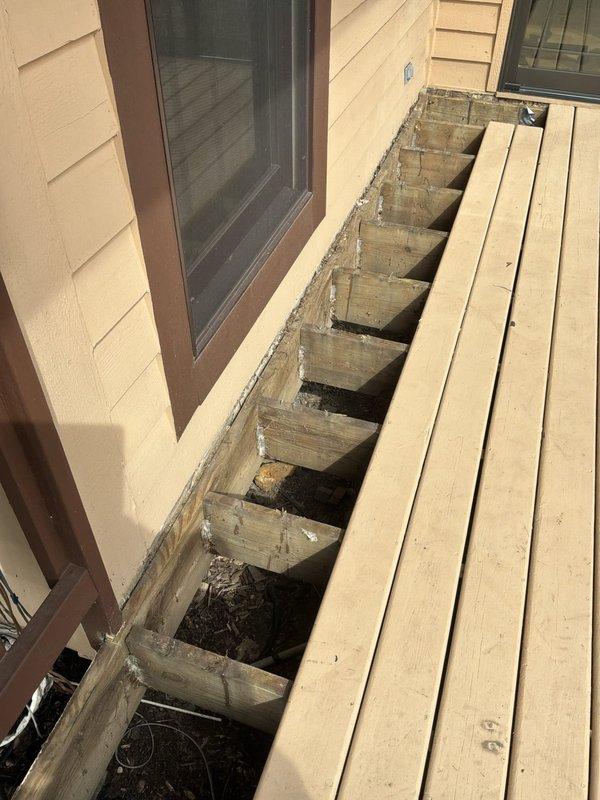 Completed estimate for installation of natural gas line from basement to outdoor grill location. Assessed existing gas infrastructure in basement crawl space, including current gas piping, shut-off valves, and routing options through floor joists. Evaluated exterior access point at wooden deck area where deck boards would require temporary removal to facilitate piping installation beneath deck structure to reach grill location. Documented existing conditions including current gas line configuration with yellow corrugated flexible connectors (CSST), rigid black iron pipe, and shut-off valve locations. Photographed proposed routing path through basement joists and exterior deck framing to determine material requirements and labor scope for approximately 10-12 feet of gas line installation.