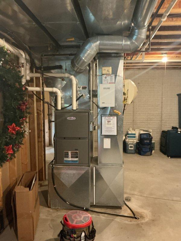 Responded to AC service call and performed diagnostic testing on outdoor condensing unit. Used digital multimeter to measure electrical readings at capacitor and contactor assembly, obtaining voltage reading of 499V. Inspected internal electrical components including run capacitor with yellow and blue wire connections and contactor relay. Accessed indoor air handler unit FTU-2588-10 located in basement mechanical room. Verified proper operation of furnace and air handling equipment. System tested and operational upon completion of service visit.