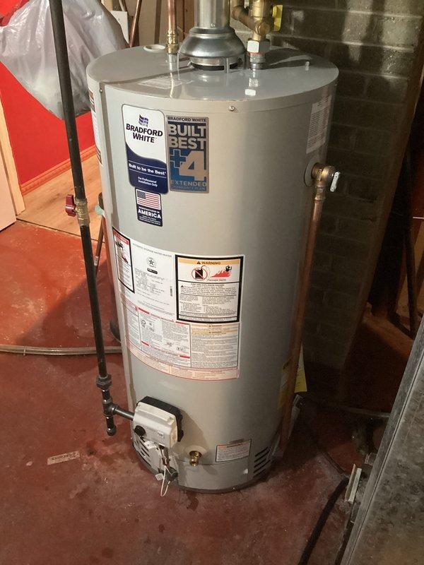 Installed 40-gallon Bradford White standard vent gas water heater in basement utility area. Unit was properly positioned, connected to existing copper supply lines with heat traps, installed pressure relief valve with discharge piping, and connected to gas supply with all necessary shut-off valves and controls verified operational.