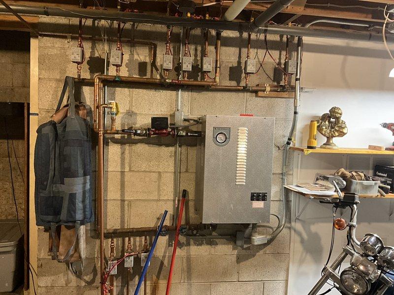 Conducted estimate for boiler replacement in basement utility area. Customer currently operates electric boiler system and requested conversion to propane-fired unit. Assessed existing hydronic heating distribution system with copper piping manifolds, evaluated electrical panel configuration, and confirmed walk-out basement access for equipment delivery and installation.