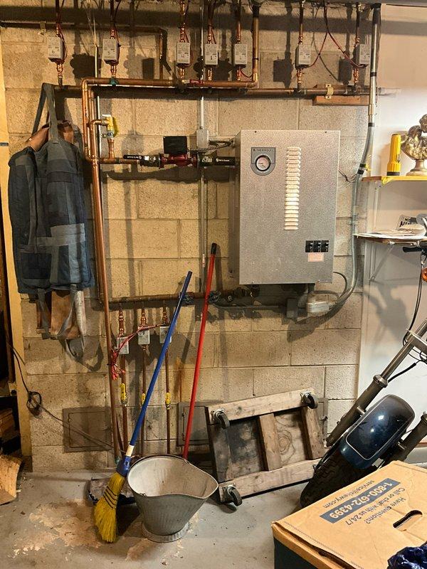 Conducted estimate for boiler replacement in basement utility area. Customer currently operates electric boiler system and requested conversion to propane-fired unit. Assessed existing hydronic heating distribution system with copper piping manifolds, evaluated electrical panel configuration, and confirmed walk-out basement access for equipment delivery and installation.