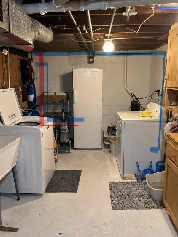 Conducted site assessment for new basement bathroom installation in unfinished concrete space with no existing plumbing infrastructure. Evaluated current utility room layout, identified available copper supply lines and drainage access points in exposed ceiling, and documented existing conditions including appliance placement and structural considerations for routing new water supply and waste lines through concrete floor.