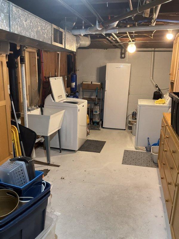 Conducted site assessment for new basement bathroom installation in unfinished concrete space with no existing plumbing infrastructure. Evaluated current utility room layout, identified available copper supply lines and drainage access points in exposed ceiling, and documented existing conditions including appliance placement and structural considerations for routing new water supply and waste lines through concrete floor.
