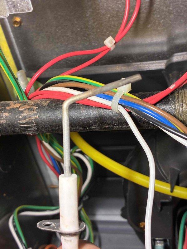 Responded to service alert from thermostat indicating unit required maintenance. Performed comprehensive tune-up on HVAC system, inspecting electrical connections, wiring integrity, and component condition. Observed deteriorated insulation on refrigerant line requiring attention and documented existing wire management with bundled connections secured along infrastructure. Reset thermostat service alert and updated maintenance schedule to reflect correct service interval date for future notifications.