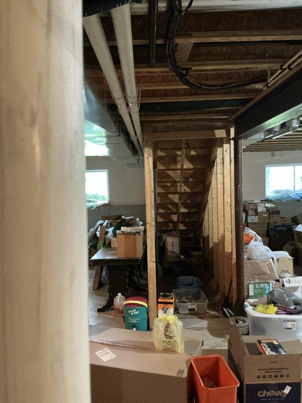 Conducted furnace replacement estimate in unfinished basement area with exposed joists and existing HVAC infrastructure. Evaluated current system configuration, assessed available utility connections including existing PVC venting and electrical conduit, and provided equipment replacement recommendations to homeowner and family representative.