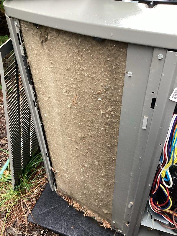 Completed comprehensive furnace and air conditioning tune-up service including full system inspection and air distribution adjustment. Accessed outdoor condensing unit, identified and replaced heavily soiled air filter that was densely packed with dust, dirt, and debris causing restricted airflow. Inspected condenser coil fins, electrical connections, and overall unit operation to ensure optimal system performance.