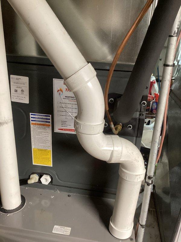 Completed comprehensive A/C tune-up on residential Rheem HVAC system located in basement mechanical room. Performed full system inspection including furnace cabinet, air handler, refrigerant lines, condensate drain system, and all associated components. Verified proper operation of white PVC exhaust and intake venting, checked copper refrigerant line connections, and confirmed all manufacturer labels and safety information remain legible and intact. System found to be in good working condition with organized component arrangement and clean installation.